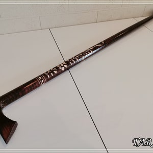 May include: A dark brown wooden walking stick with a carved floral design and a T-shaped handle.
