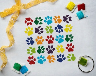 May include: A colorful cross-stitch pattern of 25 paw prints in a rainbow of colors. The paw prints are arranged in a square grid.
