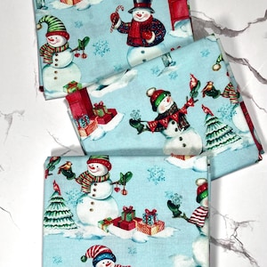Tessuto di cotone con pupazzi di neve blu di Fabric Editions, quarti di grasso natalizi