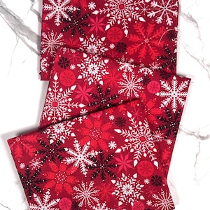 Tessuto di cotone con fiocchi di neve rossi di Fabric Editions, quarti di grasso natalizi