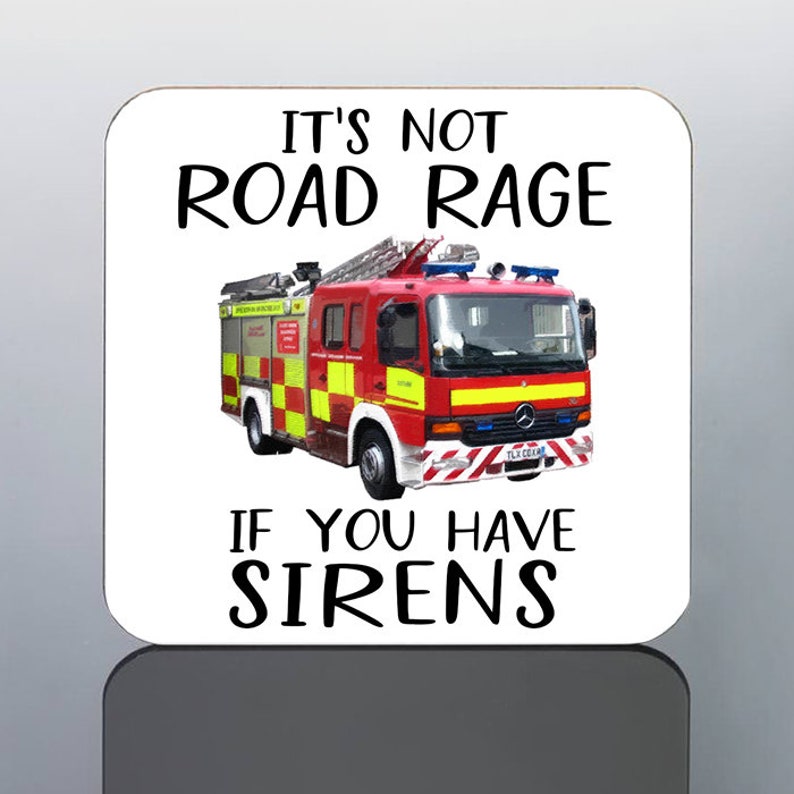 May include: A square coaster with rounded corners featuring a red and yellow fire truck illustration. The text reads "IT'S NOT ROAD RAGE IF YOU HAVE SIRENS" in black font. The coaster has a glossy finish.