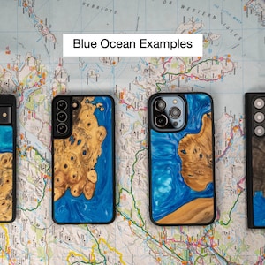 K&ouml;nnte beinhalten: Vier verschiedene Handyh&uuml;llen mit einem Design aus blauem Ozean und Holz. Die H&uuml;llen sind alle schwarz und haben ein klares Harzdesign mit blauen und wei&szlig;en Wirbeln. Die H&uuml;llen liegen auf einer Karte.