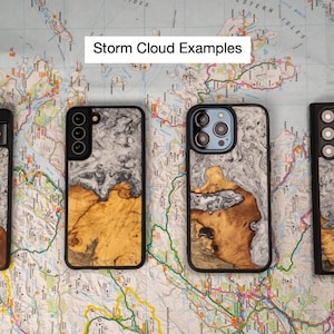 K&ouml;nnte beinhalten: Vier verschiedene Handyh&uuml;llen mit einem Design aus Holz und Harz. Die H&uuml;llen sind alle schwarz und haben ein wei&szlig;-braunes Marmormuster. Der Text "Storm Cloud Examples" befindet sich oben im Bild.
