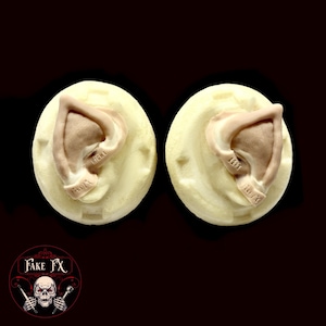 May include: Two beige foam molds with pointed ears, one labeled "LEFT" and the other "RIGHT".