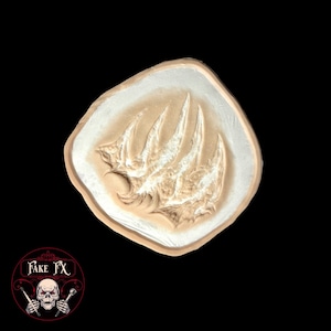 Peut inclure: Une prothèse de blessure avec un motif de griffes. L'application en latex est de couleur beige clair avec une bordure blanche, sur fond noir. Le produit est de Fake FX.