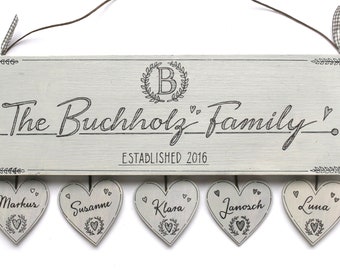 Türschild Familie aus Holz mit Monogramm, personalisiert mit Namen und Herzanhänger. Einzigartiges Geschenk zur Geburt oder Hochzeit.