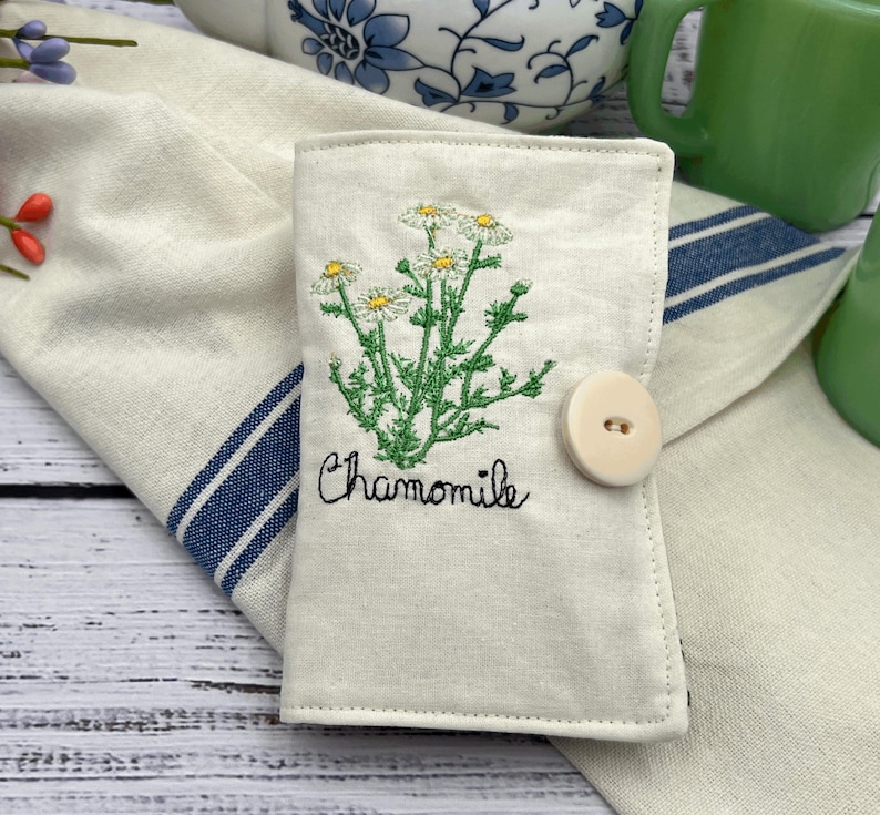 This is a tea wallet. It is made out of premium Muslim on the outside with a chamomile plant and the word chamomile on the outside front. It has six pockets to hold teabags sweetener, lens, cleaners, or anything else that this little wallet might be able to hold.