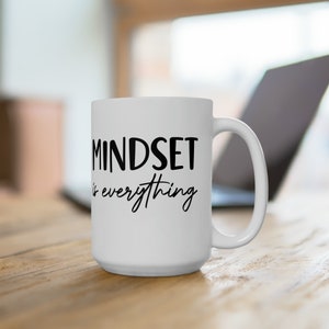 Puede incluir: Taza de café de cerámica blanca con texto negro que dice "MINDSET is everything".