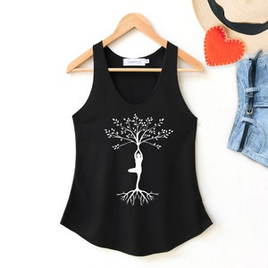 May include: Black tank top with a white silhouette of a person in a yoga pose, forming the shape of a tree with branches and roots.