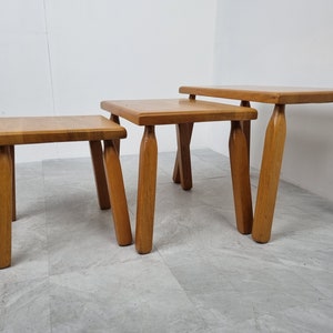 Puede incluir: Conjunto de tres mesas nido de madera con acabado natural. Las mesas son cuadradas y tienen cuatro patas cada una. Las patas est&aacute;n ligeramente acampanadas en la parte inferior.