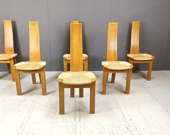 Puede incluir: Conjunto de seis sillas de comedor de madera con asientos de caña trenzada. Las sillas tienen un respaldo alto y delgado y un diseño simple y moderno.