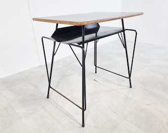 May include: A black metal table with a wooden top and a lower shelf. The table has a simple, modern design.
