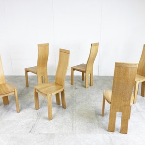 May include: Five wooden chairs with a light brown finish. The chairs have a curved back and a simple design.