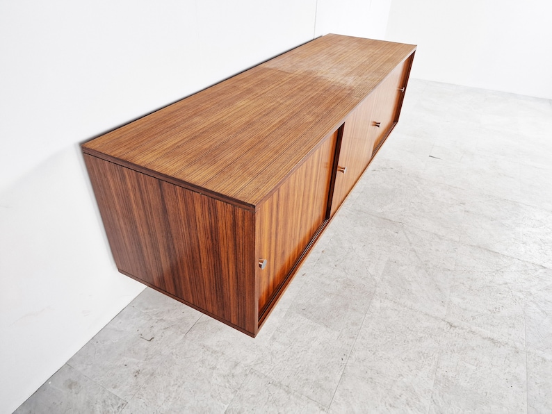 May include: A dark wood wall-mounted cabinet with sliding doors and silver handles. The cabinet has a sleek, modern design.