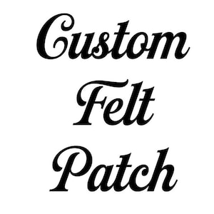 May include: A white background with black text in a cursive font. The text reads "Custom Felt Patch", stacked vertically. The words are in a stylish, elegant font, suitable for custom felt patches.