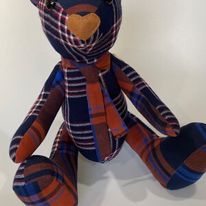 May include: A handmade plaid teddy bear made from blue, red and white checked fabric. The bear has brown felt eyes and a brown felt nose.