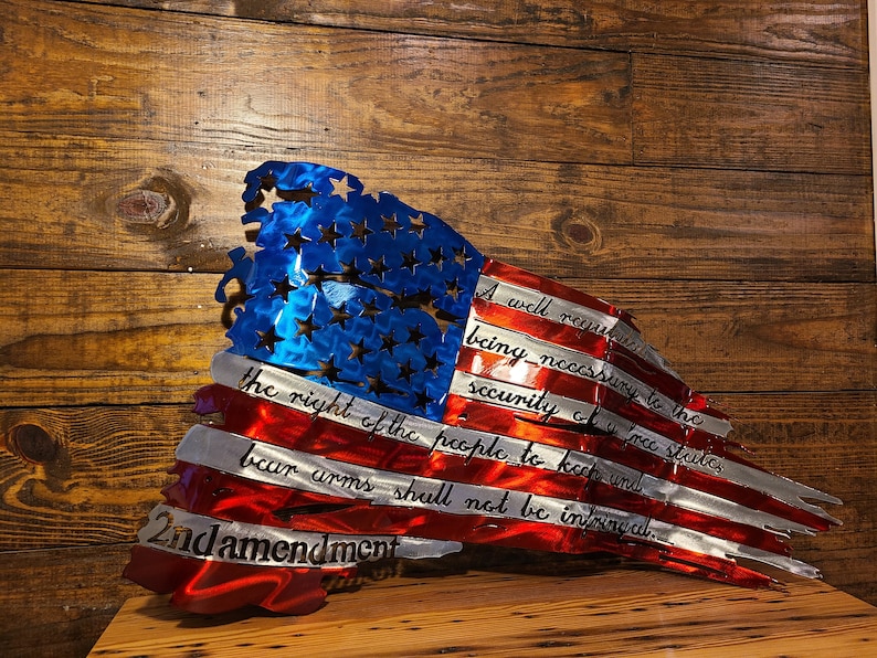 May include: A distressed metal American flag with the 2nd Amendment text: "A well regulated Militia, being necessary to the security of a free State, the right of the people to keep and bear Arms, shall not be infringed."