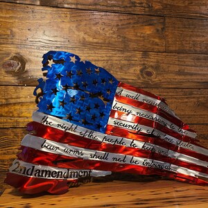 May include: A distressed metal American flag with the 2nd Amendment text: "A well regulated Militia, being necessary to the security of a free State, the right of the people to keep and bear Arms, shall not be infringed."