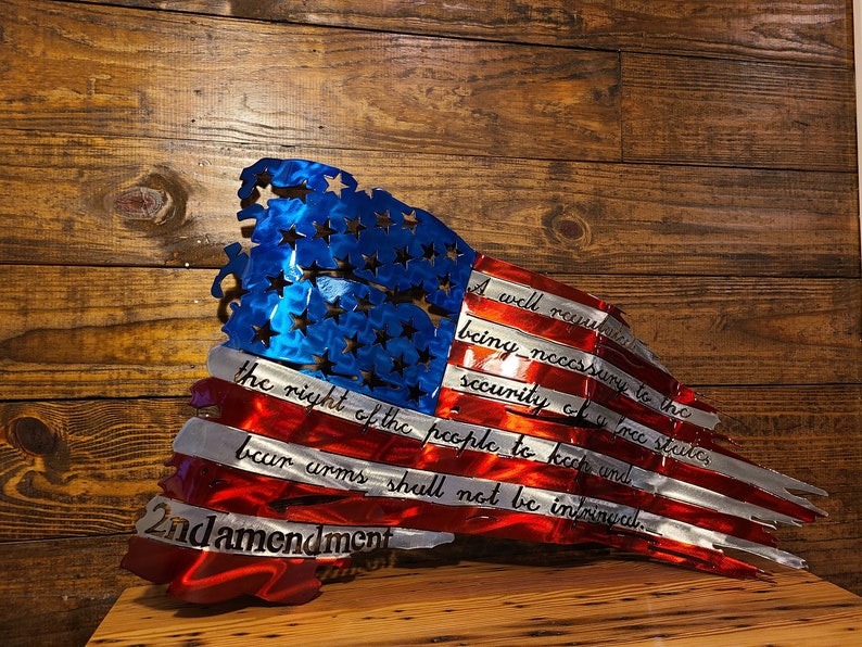 May include: A distressed metal American flag with the 2nd Amendment text: "A well regulated Militia, being necessary to the security of a free State, the right of the people to keep and bear Arms, shall not be infringed."