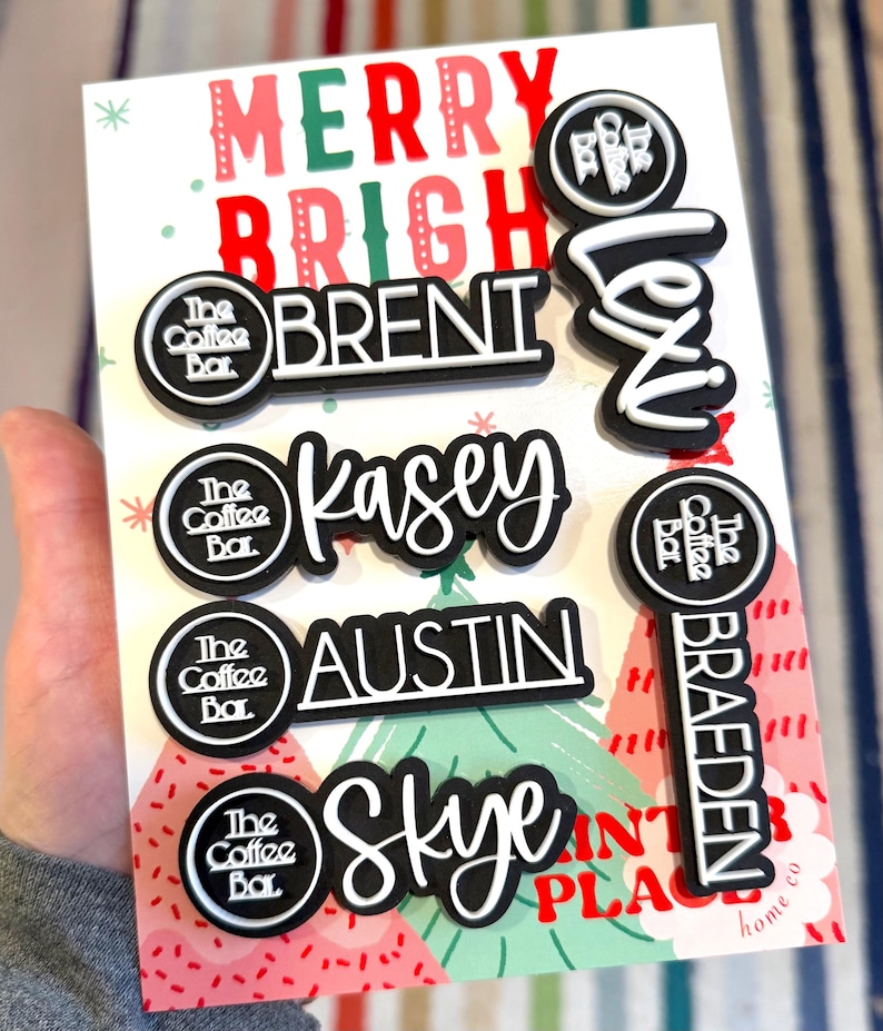 Puede incluir: Un conjunto de etiquetas con nombres en blanco y negro con el texto &laquo;MERRY BRIGHT&raquo; en una tarjeta navide&ntilde;a. Las etiquetas presentan nombres como &laquo;Brent&raquo;, &laquo;Kasey&raquo;, &laquo;Austin&raquo;, &laquo;Skye&raquo;, &laquo;Lexi&raquo; y &laquo;Braeden&raquo;. Tambi&eacute;n est&aacute; presente el logotipo de The Coffee Bar.