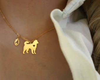 Peut inclure: Un collier en or avec un petit pendentif en forme de feuille avec la lettre A et un plus grand pendentif en forme de silhouette de chien avec un cœur à l'intérieur.
