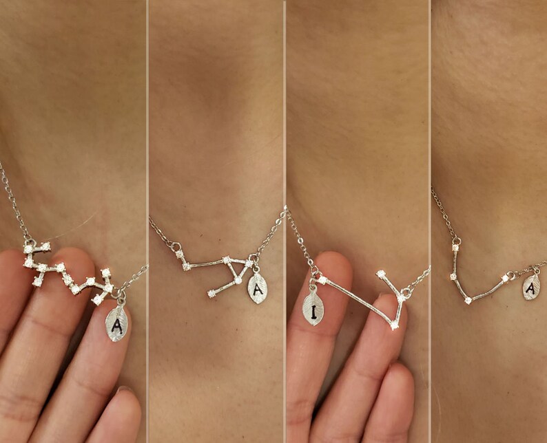 May include: Four silver necklaces with a constellation design and a small pendant with a letter on each. The constellations are different on each necklace. The pendants are all the letter A.