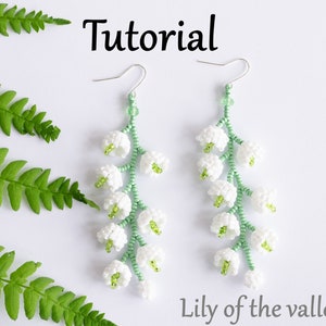 May include: A pair of delicate earrings featuring lily of the valley flowers made with white and green beads. The earrings are hanging from silver hooks. The text "Tutorial" and "Lily of the valley" are visible in the image.
