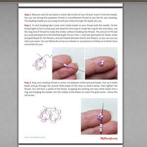 Peut inclure: Instructions &eacute;tape par &eacute;tape pour r&eacute;aliser une fleur en perles blanches et roses. L'image montre un gros plan du processus de perlage, avec l'aiguille enfil&eacute;e &agrave; travers les perles et la fleur prenant forme.