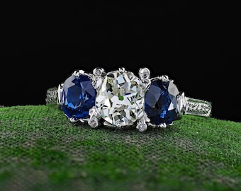 Anel antigo Art Déco em platina com três pedras: diamante e safira.