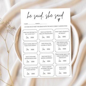 Peut inclure: Une carte de jeu "He Said, She Said" en noir et blanc. La carte présente une série de questions avec des options "her" et "him" pour les réponses. La carte est sur une assiette blanche, avec les mots "he said, she said" en haut.