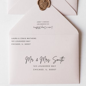 May include: A white envelope with a pink hue, addressed to Mr. & Mrs. Smith, 123 Lougheed Way, Chicago, IL 60007. The envelope has a wax seal in the upper right corner.