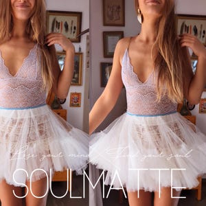 May include: A white tulle skirt with a blue ribbon waistband and a lace top. The skirt is layered and has a ruffled hem. The text "Lose your mind, find your soul. SOULMATE" is printed on the skirt.