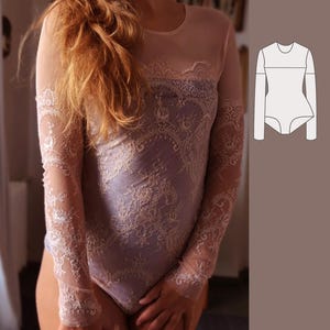 Pode incluir: Um body roxo com mangas compridas de renda delicada. As mangas são transparentes e têm um padrão floral. O body tem um decote redondo e uma silhueta ajustada.