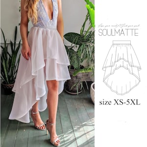 以下が含まれることがあります： フリルのある裾が特徴の、白の多層ハイローチュールスカート。スカートはモデル着用で、重なり合ったレイヤーのパターンになっています。スカートはXS-5XLサイズ展開です。スカートの上に「Lose your mind. Find your soul. SOULMATTE」というテキストが表示されています。