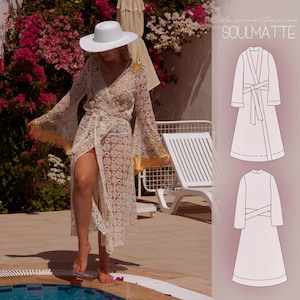 Puede incluir: Un sombrero blanco de ala ancha y una bata de encaje de manga larga estilo cruzado con patrón geométrico, flecos dorados en las mangas y cinturón. La imagen incluye un dibujo técnico de la prenda con el texto SOULMATTE.