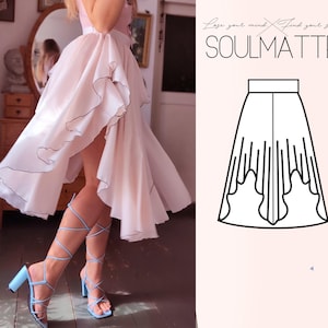 Puede incluir: Una falda rosa claro asimétrica con ribete negro y un top a juego. La falda tiene un diseño fluido. La imagen también presenta sandalias de tacón con tiras azul claro. El texto "SOULMATTE" es visible.