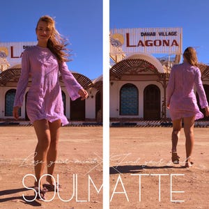 May include: A woman in a purple dress walks towards the camera in front of a building with a sign that reads "Dahab Village Lagona".