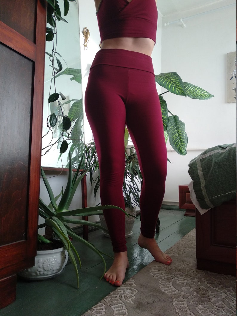 May include: A pair of burgundy leggings with a high waist. The leggings are made of a soft, stretchy fabric and are perfect for yoga, running, or everyday wear.