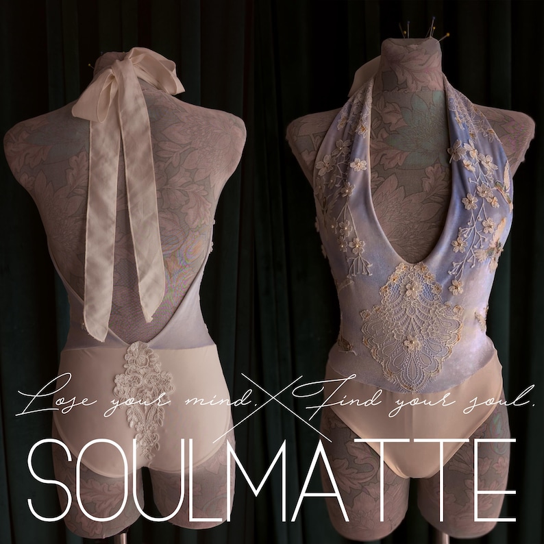 May include: A light blue and cream bodysuit featuring a deep halter neckline, intricate floral lace appliqu&eacute;s, and a tie-back closure. The garment displays the text "Lose your mind. Find your soul. SOULMATTE" across the front and back view.