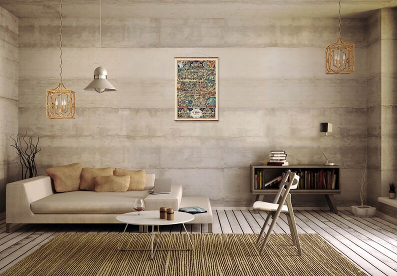 May include: A vintage map print of a city with a detailed illustration of buildings and streets. The map is framed and hanging on a wall in a modern living room with a beige couch, a coffee table, and a chair.