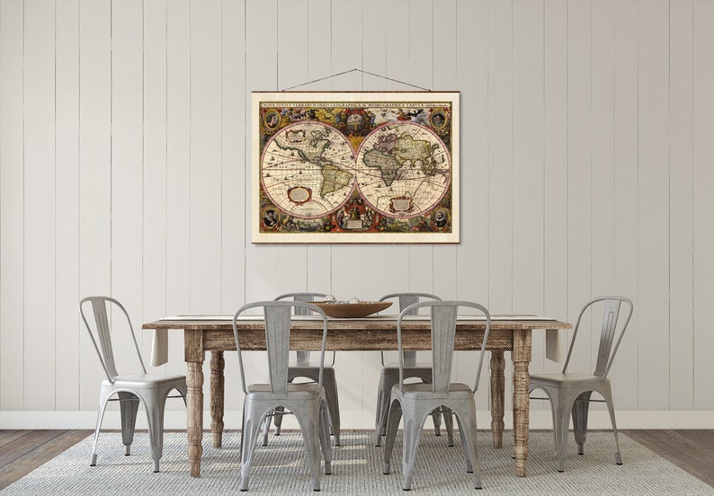 May include: A vintage world map print hangs above a rustic wooden dining table with four gray metal chairs. The map is framed in a simple brown frame and features a detailed depiction of the continents.