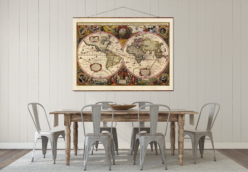 May include: A vintage world map print hangs above a rustic wooden table with four gray metal chairs. The map is framed in a simple wooden frame and features intricate details and colorful accents.