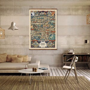 May include: A vintage map of Edinburgh, Scotland, printed on canvas and framed in a wooden frame. The map is displayed on a wall in a living room setting with a couch, coffee table, and chair.