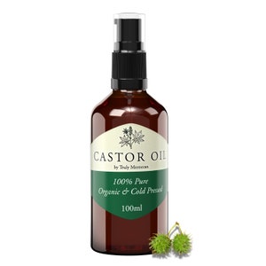 May include: A brown glass bottle with a black pump dispenser filled with castor oil. The label reads "Castor Oil by Truly Moroccan 100% Pure Organic & Cold Pressed 100ml". There are two green castor beans in the bottom right corner of the image.