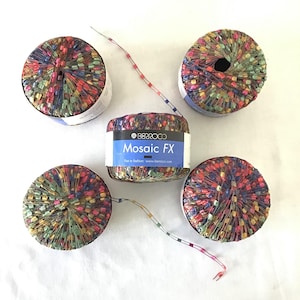 May include: Five spools of Berroco Mosaic FX yarn. The yarn is a mix of colors including red, blue, green, and yellow. The label on one spool reads "Berroco Mosaic FX". The yarn is wound into round spools.