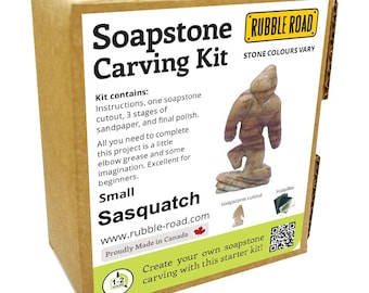 May include: A small soapstone carving kit featuring a Sasquatch design. The kit includes instructions, sandpaper, and a soapstone cutout. The box is labeled "Soapstone Carving Kit" and "Rubble Road". The stone colors may vary.