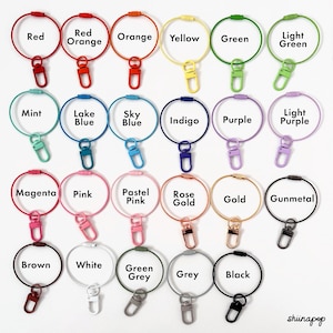 May include: Assortment of 20 colorful metal key rings with a variety of colors including red, orange, yellow, green, blue, purple, pink, gold, brown, white, grey, and black. Each key ring has a small metal hook.