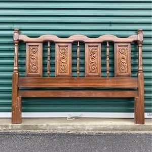 Könnte beinhalten: Ein hölzernes Kopfteil mit einem geschnitzten Design. Das Kopfteil ist aus dunklem Holz und hat eine rechteckige Form. Es hat ein schlichtes, elegantes Design.