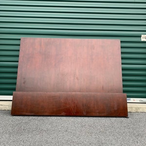 May include: A dark brown wooden headboard and footboard set. The headboard is a large, rectangular panel, and the footboard is a shorter, rectangular piece. The wood grain is visible, and the finish is smooth.