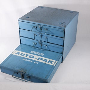 May include: A blue metal toolbox with four drawers and a pull-out tray. The tray has a white label that says "GOCAR AUTO-PAK SERVICE KIT".
